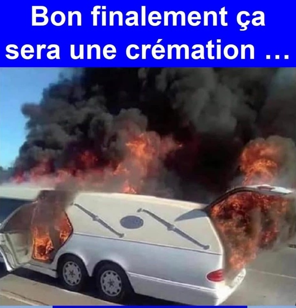 Corbillard blanc en flammes avec portes arrière ouvertes, épaisse fumée noire s'élevant, stationné sur route, bandeau bleu supérieur avec texte blanc : 'Bon finalement ça sera une crémation ...'