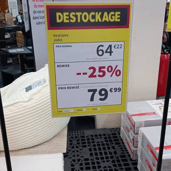 Panneau jaune de destockage pour Vestiaire John avec prix normal 64,22 euros, remise -25% et prix remisé 79,99 euros dans un magasin.