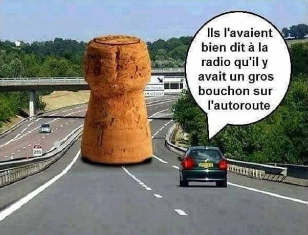 Gros bouchon de champagne en liège au milieu d'une autoroute à plusieurs voies avec une voiture qui s'approche et une bulle de texte.